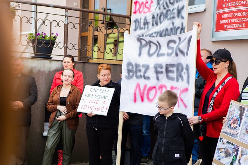 Mieszkańcy wsi Sroczyn trzymają transparenty z hasłami przeciw hodowli zwierząt na futra podczas protestu przeciwko fermie norek.