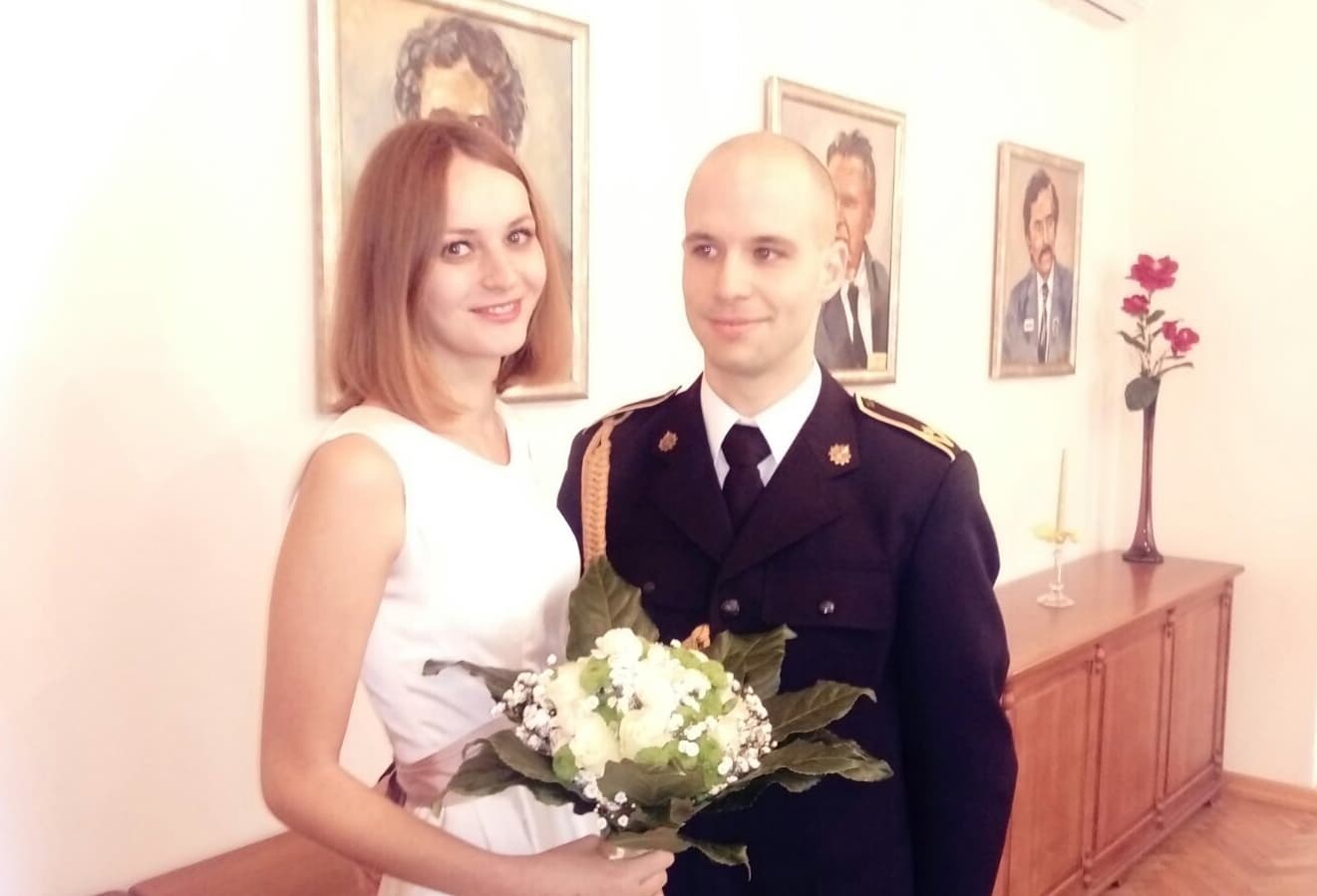 Zdjęcie z uroczystości Moniki i Maćka. Uśmiechnięci. Monika trzyma bukiet.